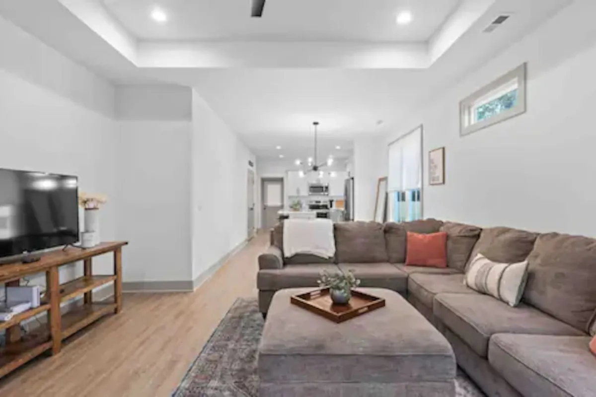 A stylish and comfortable living room featuring a sofa, coffee table, and TV, arranged for conversation or entertainment. The setting is ideal for gathering after a day out, providing a sense of community and relaxation.